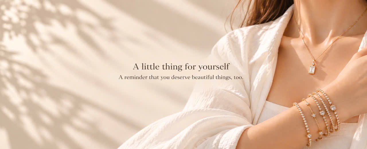 A little thing for yourself — a reminder that you deserve beautiful things, too. Woman wearing a gold pendant necklace and delicate bracelets.